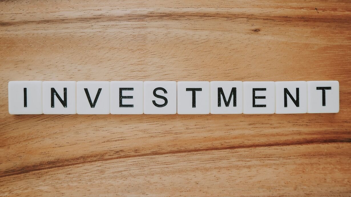 The word "investment" spelled using Scrabble letters.